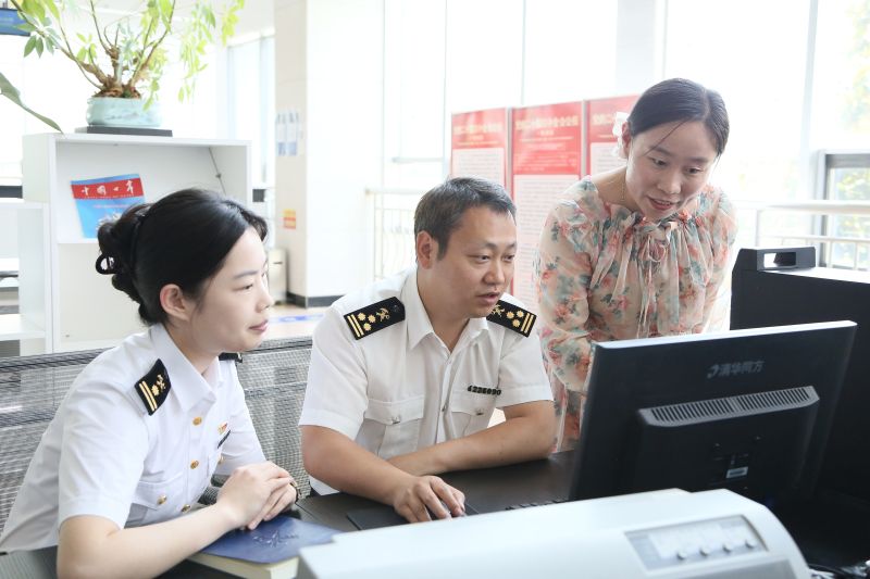 图为：报关公司业务经理向海关关员介绍“单一窗口”企业端申报录入操作梁赵慧摄